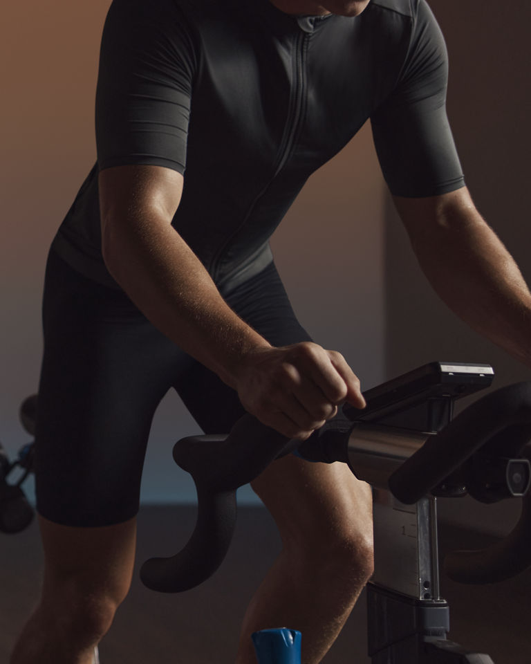 A cyclist seated on the bike riding in an EDG spin class
