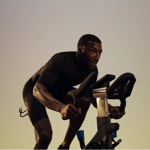 A cyclist seated on the bike riding in a PWR spin class