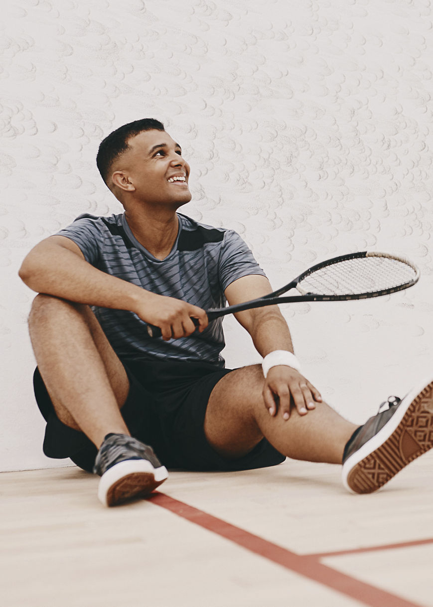 A young man taking a break after playing a game of squash