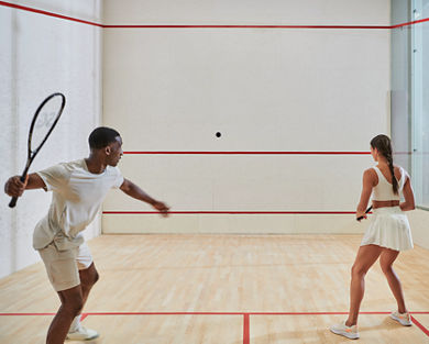 A male and female couple playing a game of squash