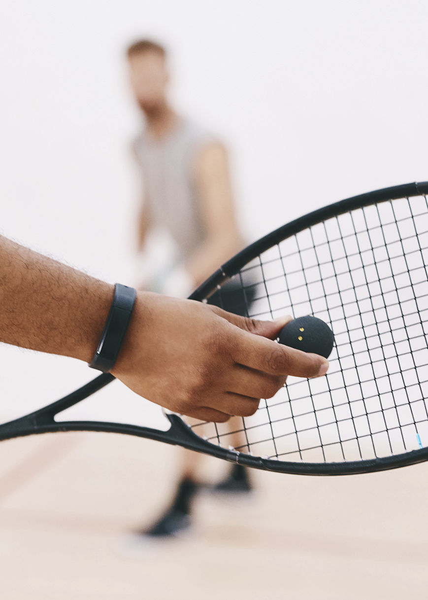 Cropped shot of a man serving a ball with a racket during a game of squash