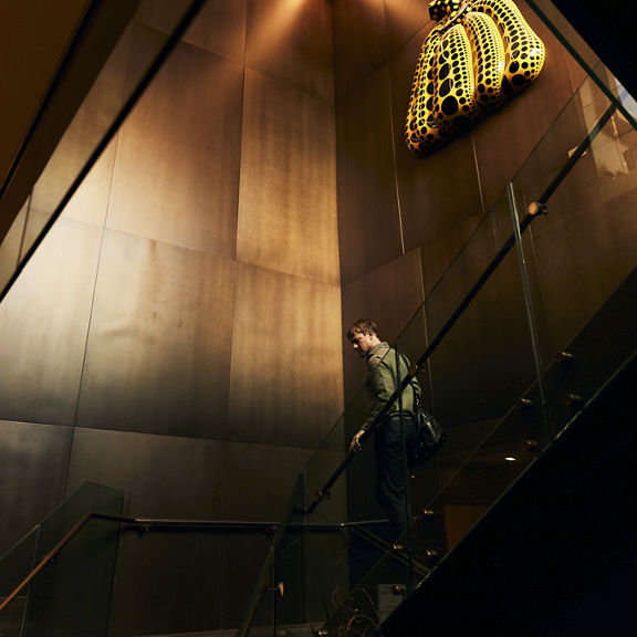 A man walking down a staircase while carrying a gym bag