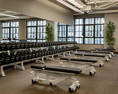 Weight benches and dumbbells on the fitness floor at the Life Time Stamford club location