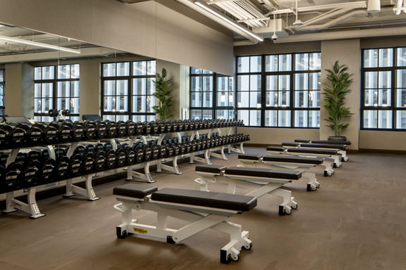 Weight benches and dumbbells on the fitness floor at the Life Time Stamford club location