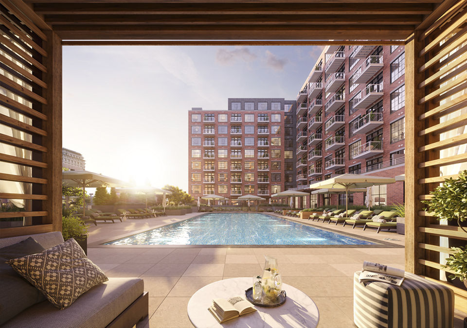 View of an outdoor pool shimmering in the sunlight from inside a cabana