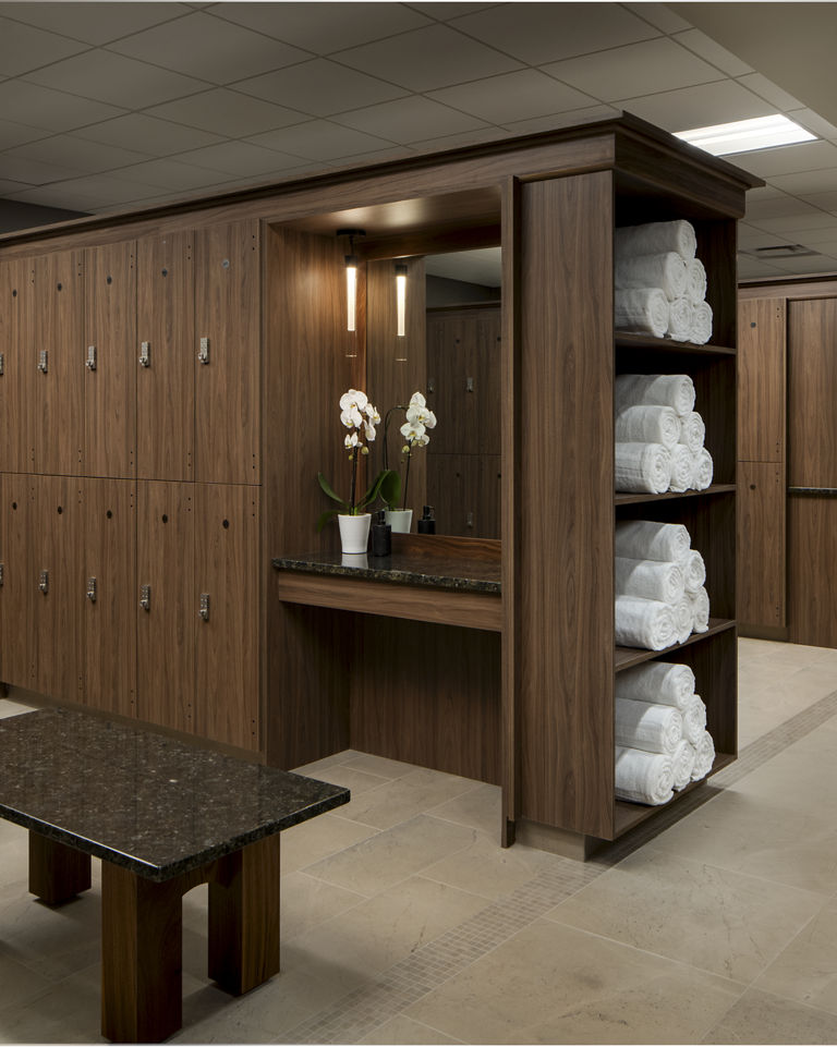 Locker bays with rolled white towels in the locker room at Life Time