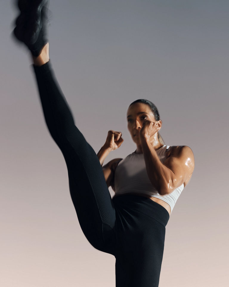 Strike kickboxing martial arts class participant in front kick position at Life Time