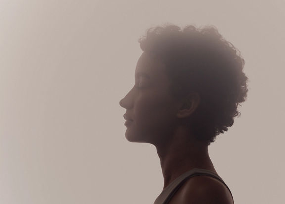 Stylized profile of a woman in a surrender yoga class at Life Time