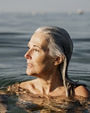 Active mature woman enjoying the beach in the morning bathing in the sea beach
