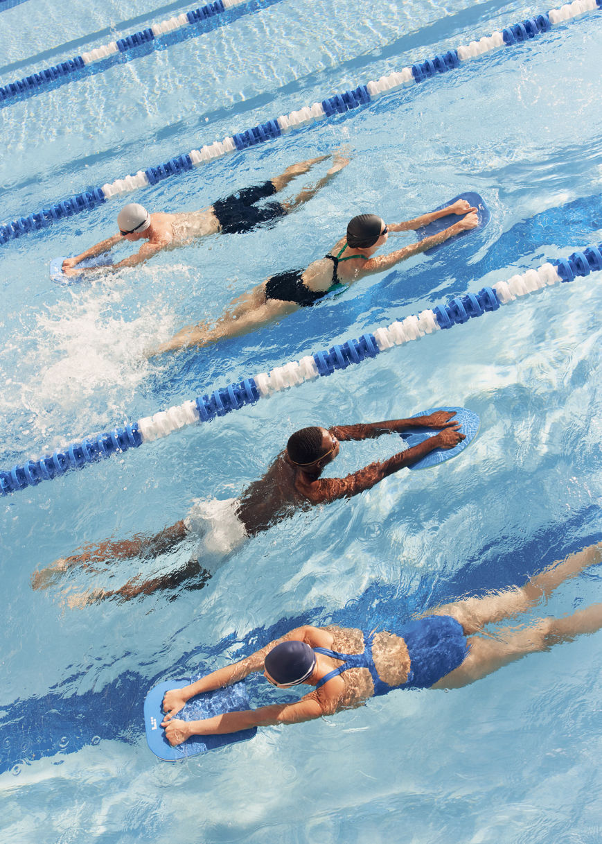 four people using kickboards in a pool
