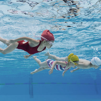 Under water view of happy kids swimming in a pool