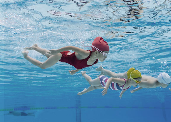 Under water view of happy kids swimming in a pool