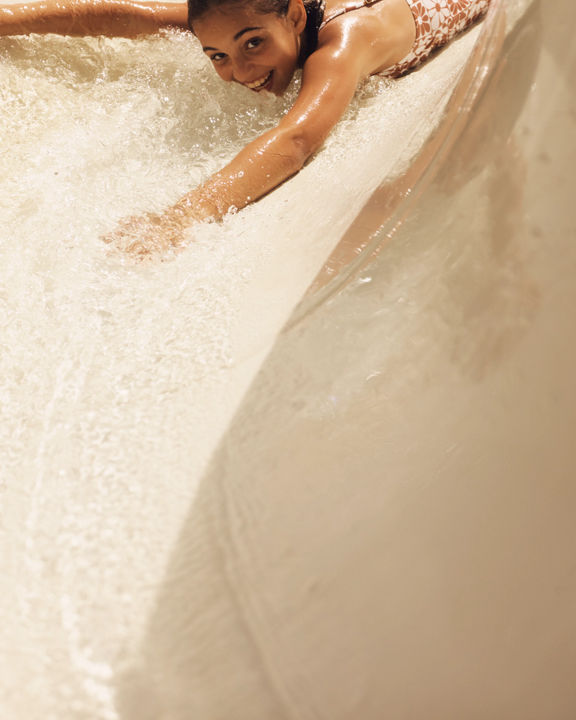 Close up of a young girl going down a waterslide