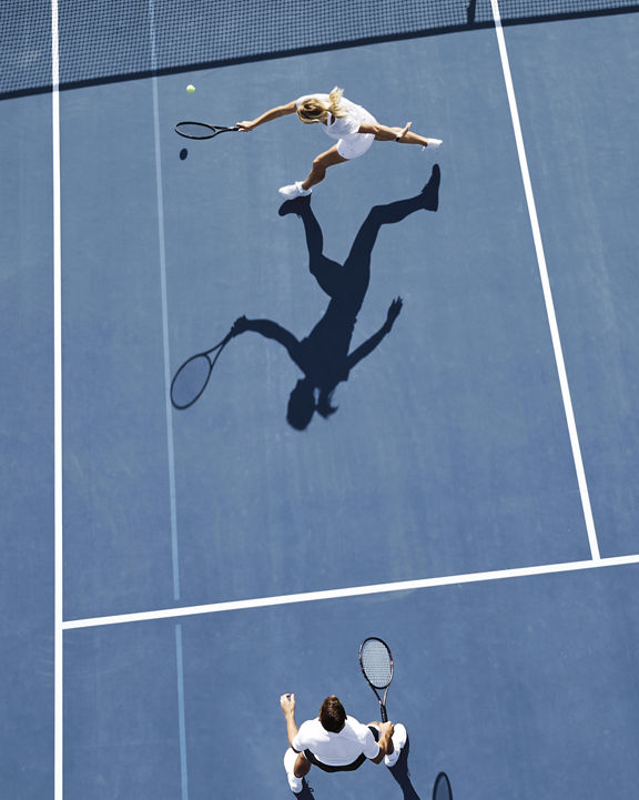 Aerial view of two people playing tennis on an outdoor tennis court