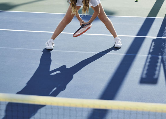 Person playing tennis on an outdoor tennis court at Life Time