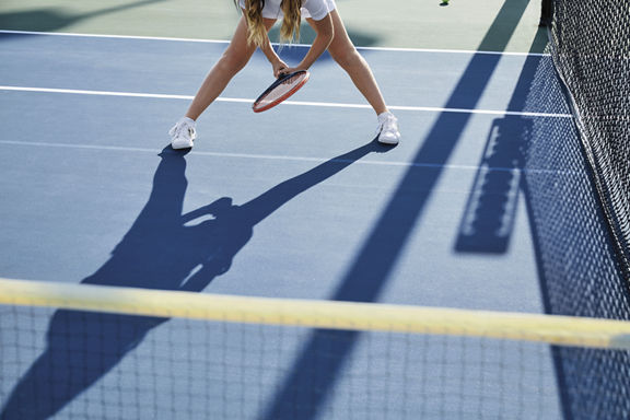 Person playing tennis on an outdoor tennis court at Life Time