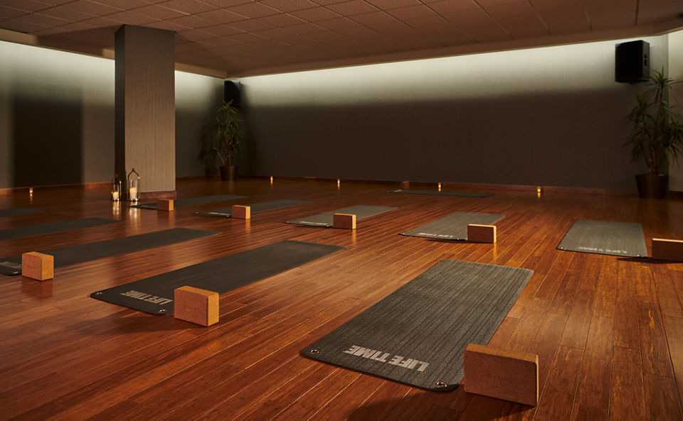 a dimly lit yoga studio with yoga mats and blocks