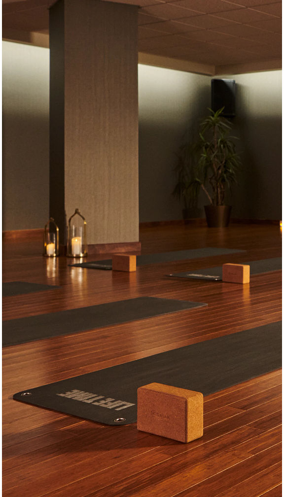 a dimly lit yoga studio with yoga mats and blocks