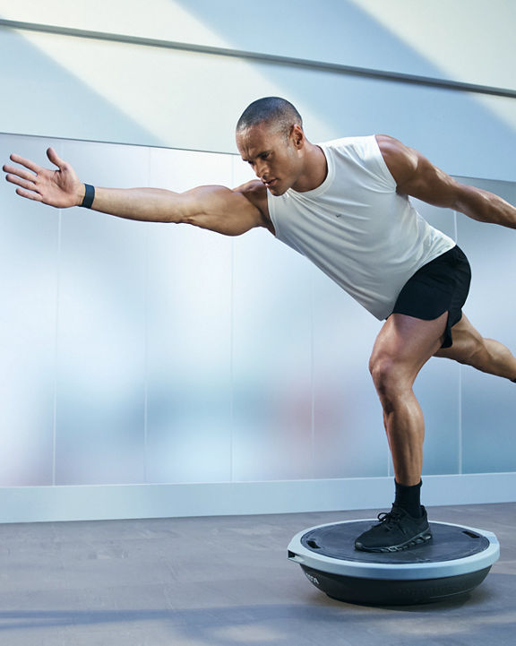 Person balancing in a lunge on a bosu ball during an UltraFit boutique group training class