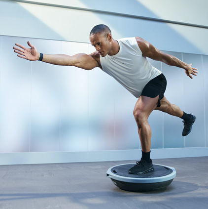 Person balancing in a lunge on a bosu ball during an UltraFit boutique group training class
