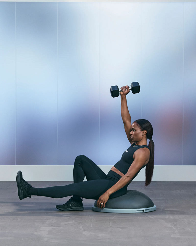 a woman doing a single arm single leg shoulder press