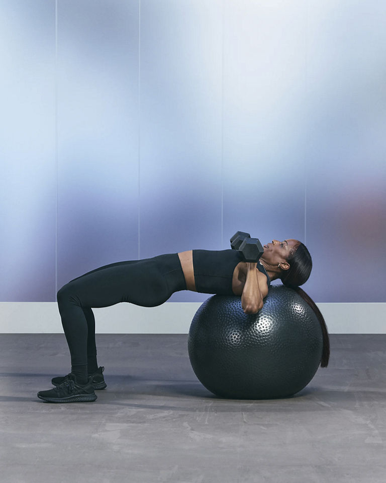 a woman doing a single leg chest press on a stability ball