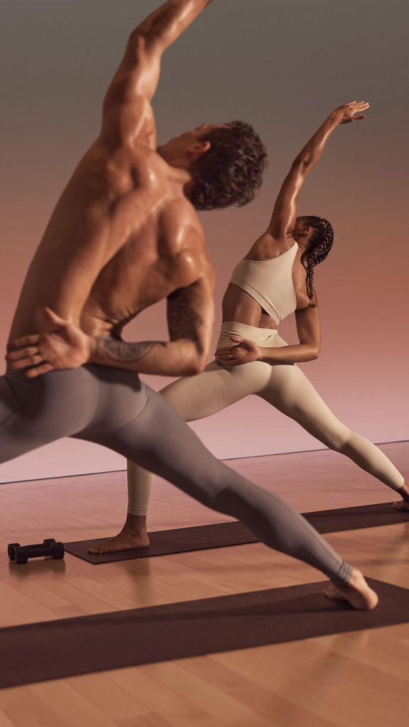 Warrior sculpt class participants in a side opener variation of a warrior pose