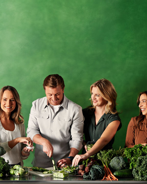Portrait of Life Time Weightloss coaches surrounded by fresh produce on a green background