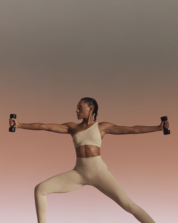 Life Time member using hand weights in warrior sculpt yoga class