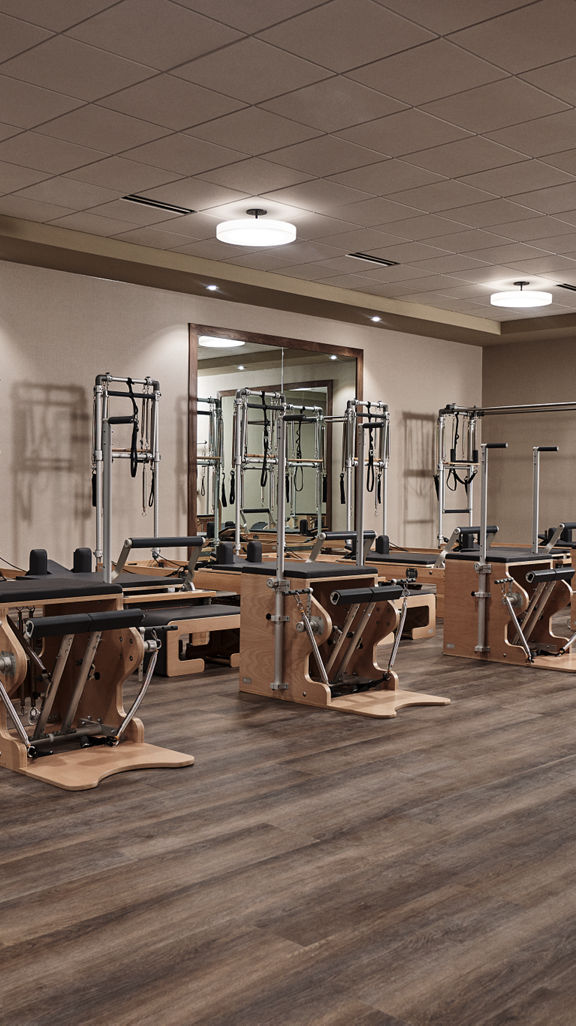 a row of pilates reformers in a pilates workout room             