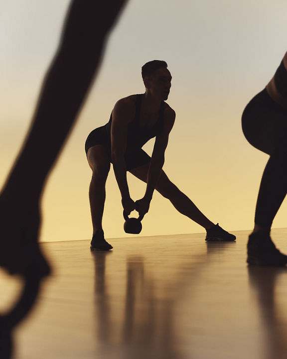 Xtreme cardio class members doing side lunges at Life Time