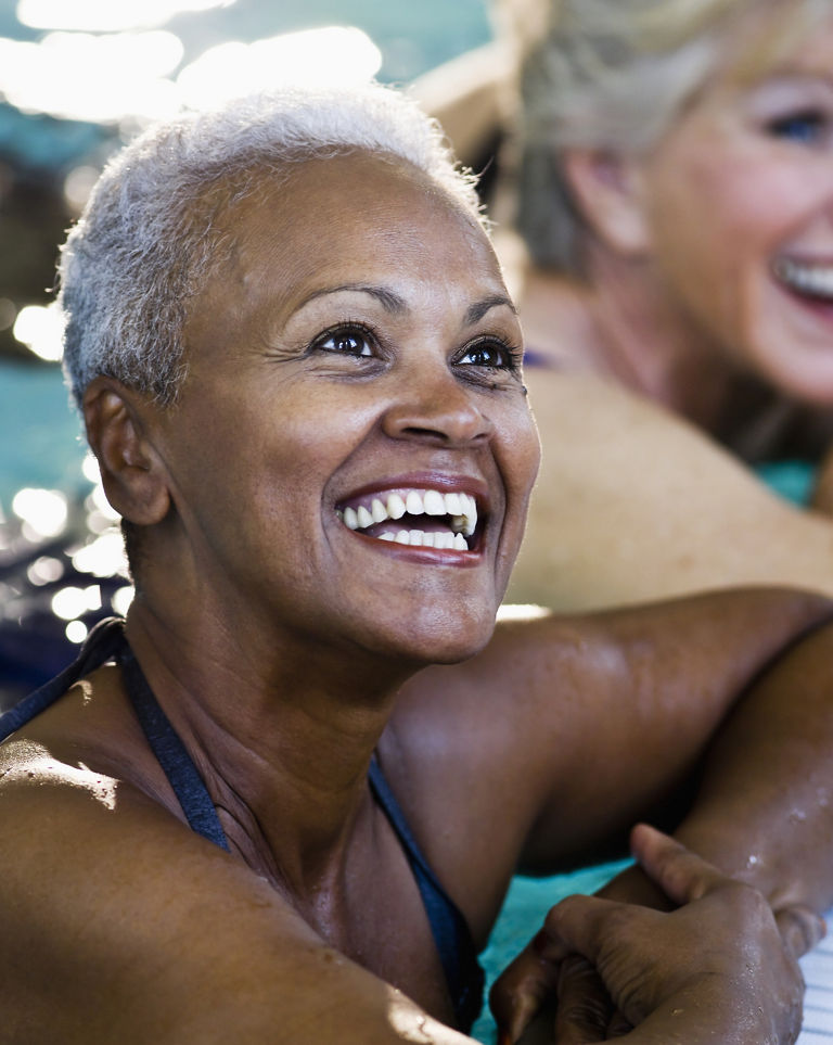 Close up of senior woman with friends (60s) at side of swimming pool