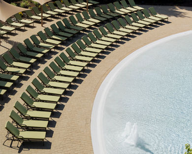 Pool lounge chairs lined up next to a zero-depth entry pool