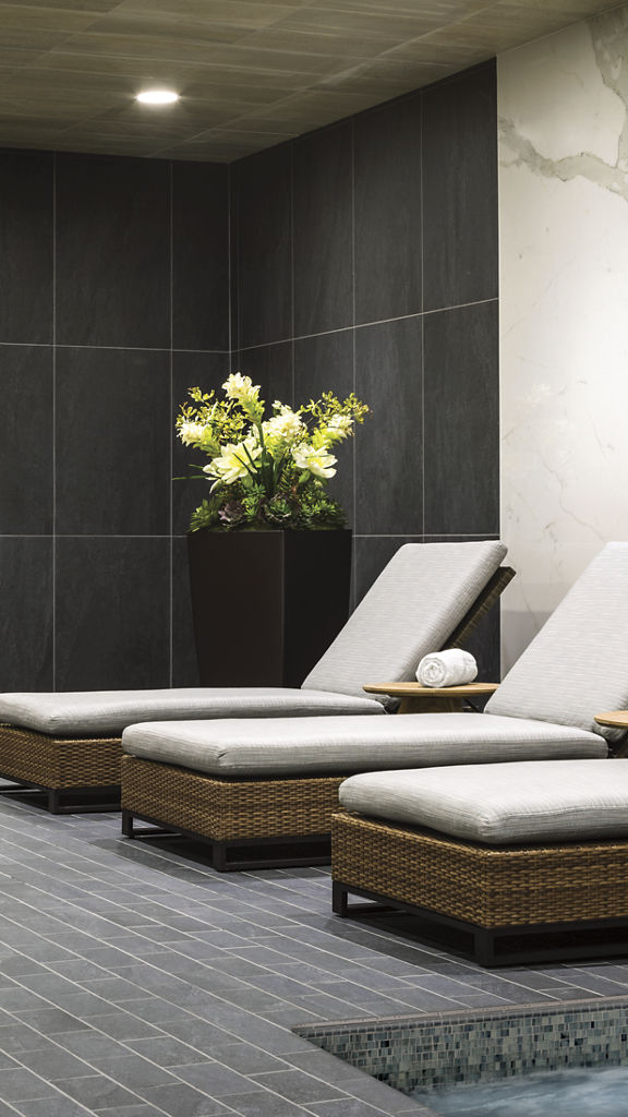 3 lounge chairs in a luxury spa area with whirlpool, cedarwood sauna, and steam room