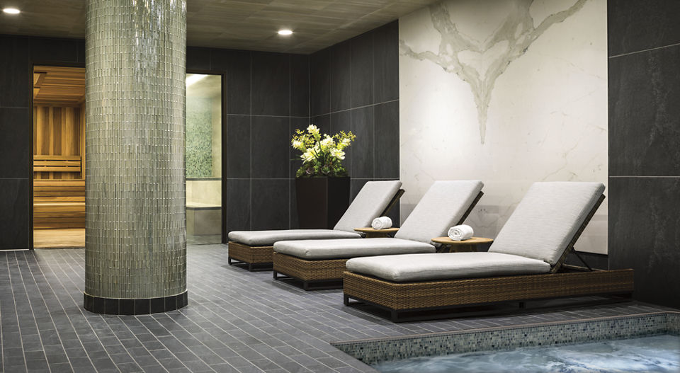 3 lounge chairs in a luxury spa area with whirlpool, cedarwood sauna, and steam room