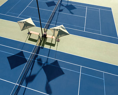 Aerial view of outdoor tennis courts with benches and umbrellas at our Folsom, California club location.