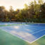 Outdoor tennis courts surrounded by trees at the Fridley Life Time club location