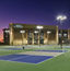 3 outdoor pickleball courts outside a Life Time at dusk