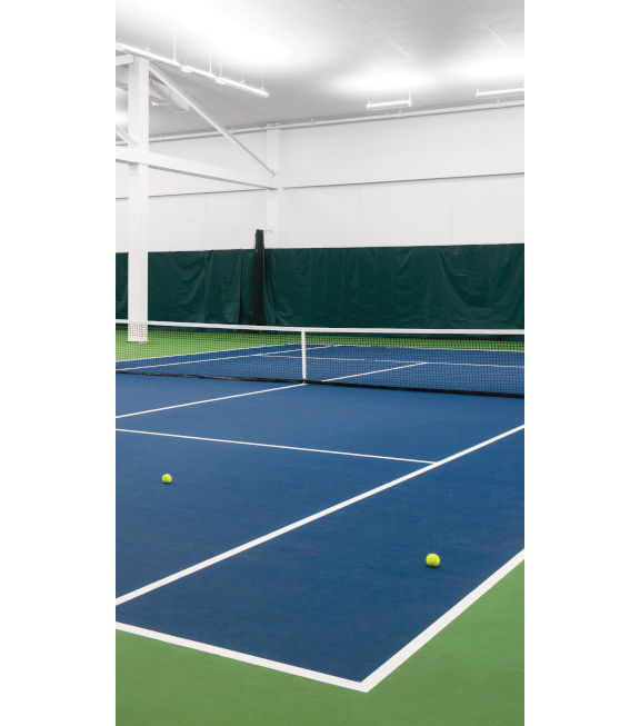 Tennis balls scattered across multiple indoor tennis courts at a Tennis facility