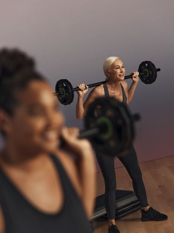 Life Time member squatting with a barbell during a Lift strength class