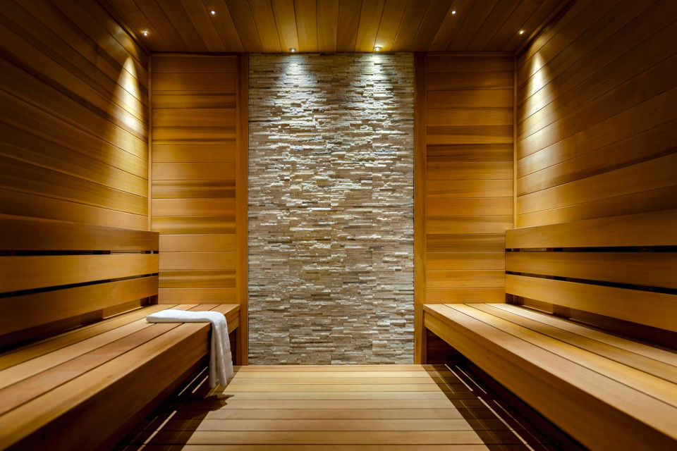 Brightly lit wooden and tiled sauna at Life Time