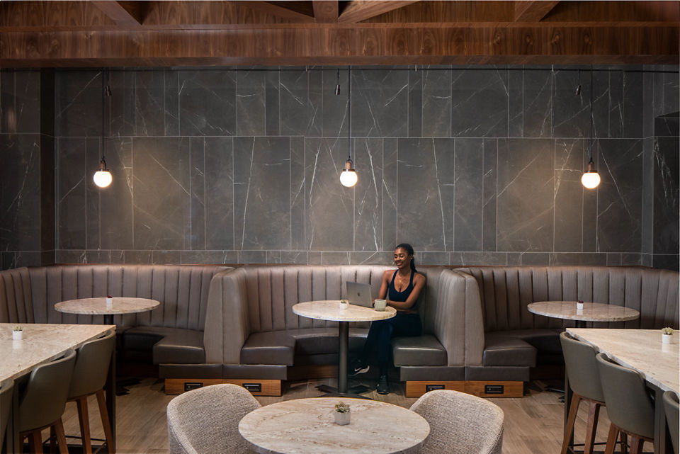 A woman sitting in a booth looking at her laptop