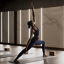 A female completing a reverse warrior pose on a mat in a yoga studio