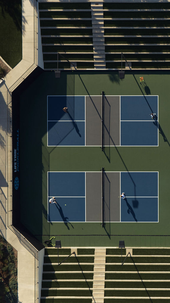 An aerial view of Life Time members playing on four outdoor pickleball courts