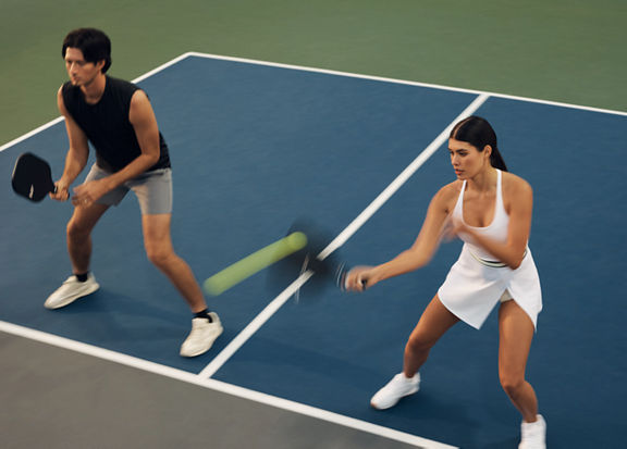 Action shot of a doubles pickleball match with one team at the kitchen
