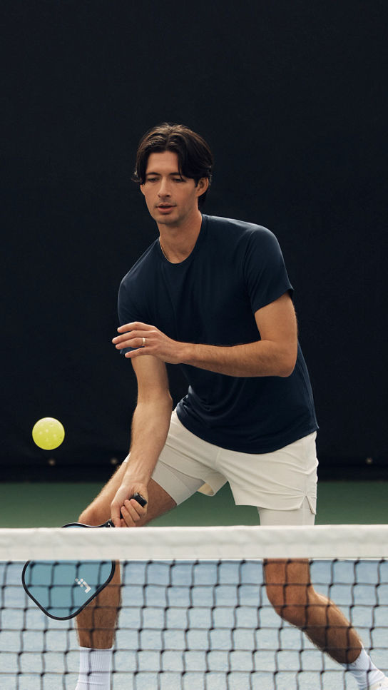 A pickleball player dinking over the net during a game at Life Time
