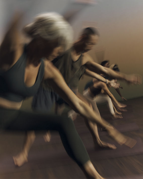 Stylized blurred image of Root yoga class participants moving through a pose at Life Time