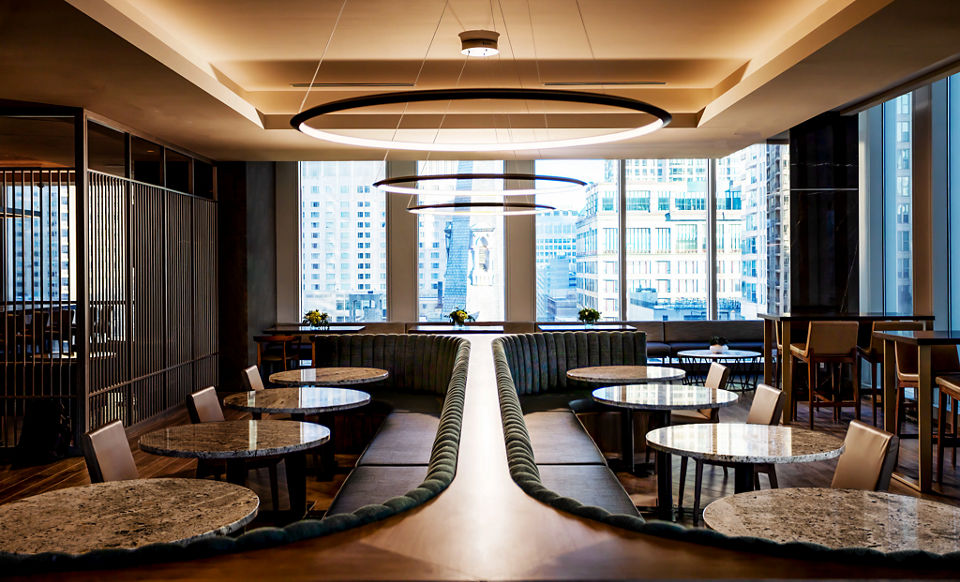 Tables, chairs, and booths in a warm dining environment