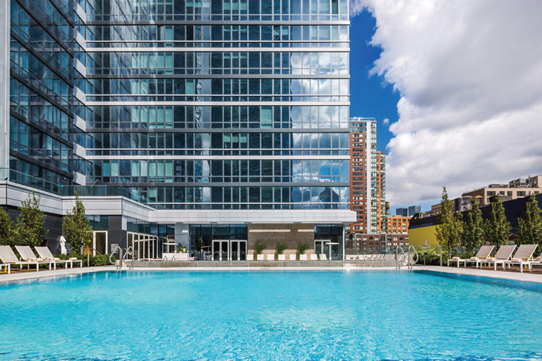 A rooftop pool deck outside a tall skyscraper building