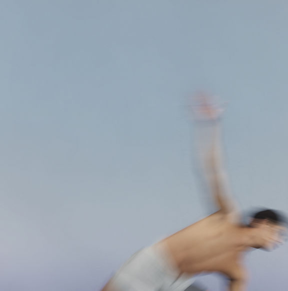 Stylized blurred image of a Sol yoga class participant moving into triangle pose at Life Time